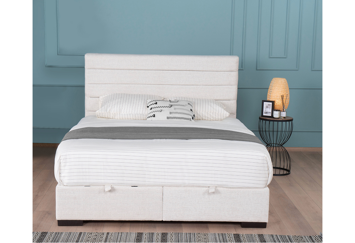 Απεικονίζεται το διπλό κρεβάτι Liberta Nirvana τοποθετημένο ανάμεσα σε δύο λευκά κομοδίνα με γκρι φωτιστικά.